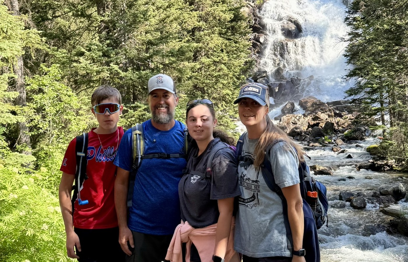 Campfires and Motors family hiking near a waterfall